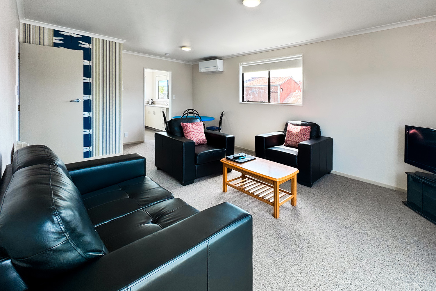 Motel lounge with black leather armchairs, coffee table and heat pump